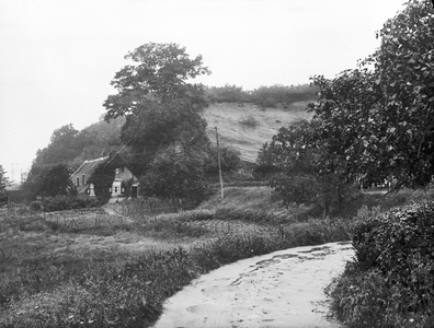 400172 Gezicht op een boederij aan de voet van de Grebbeberg te Grebbe bij Rhenen, met op de achtergrond de zandafgraving.